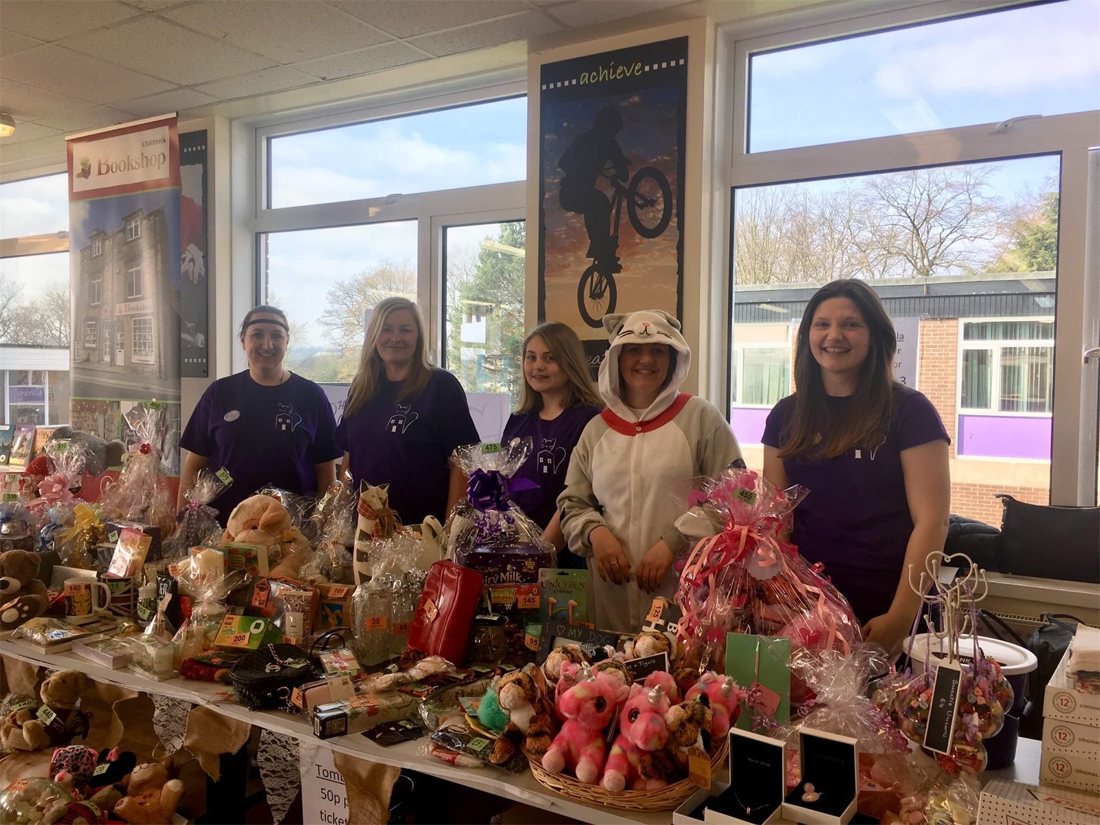 Volunteers in purple Henry's Haven t-shirts behind a tombola stall